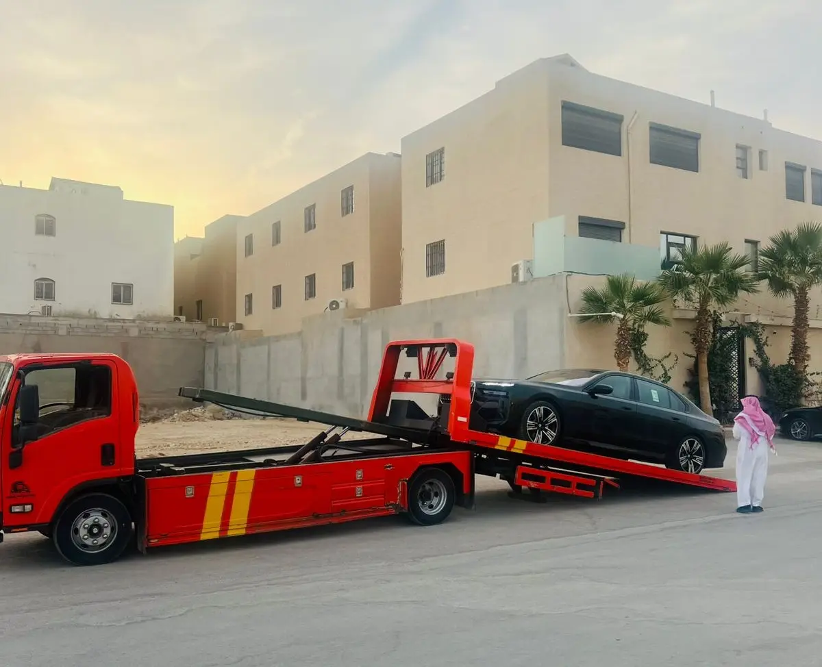 سطحة احترافية تنقل سيارة فاخرة أمام فيلا سكنية